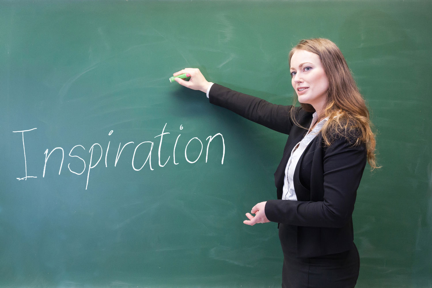 Kvinde skriver på tavle: "Inspiration"